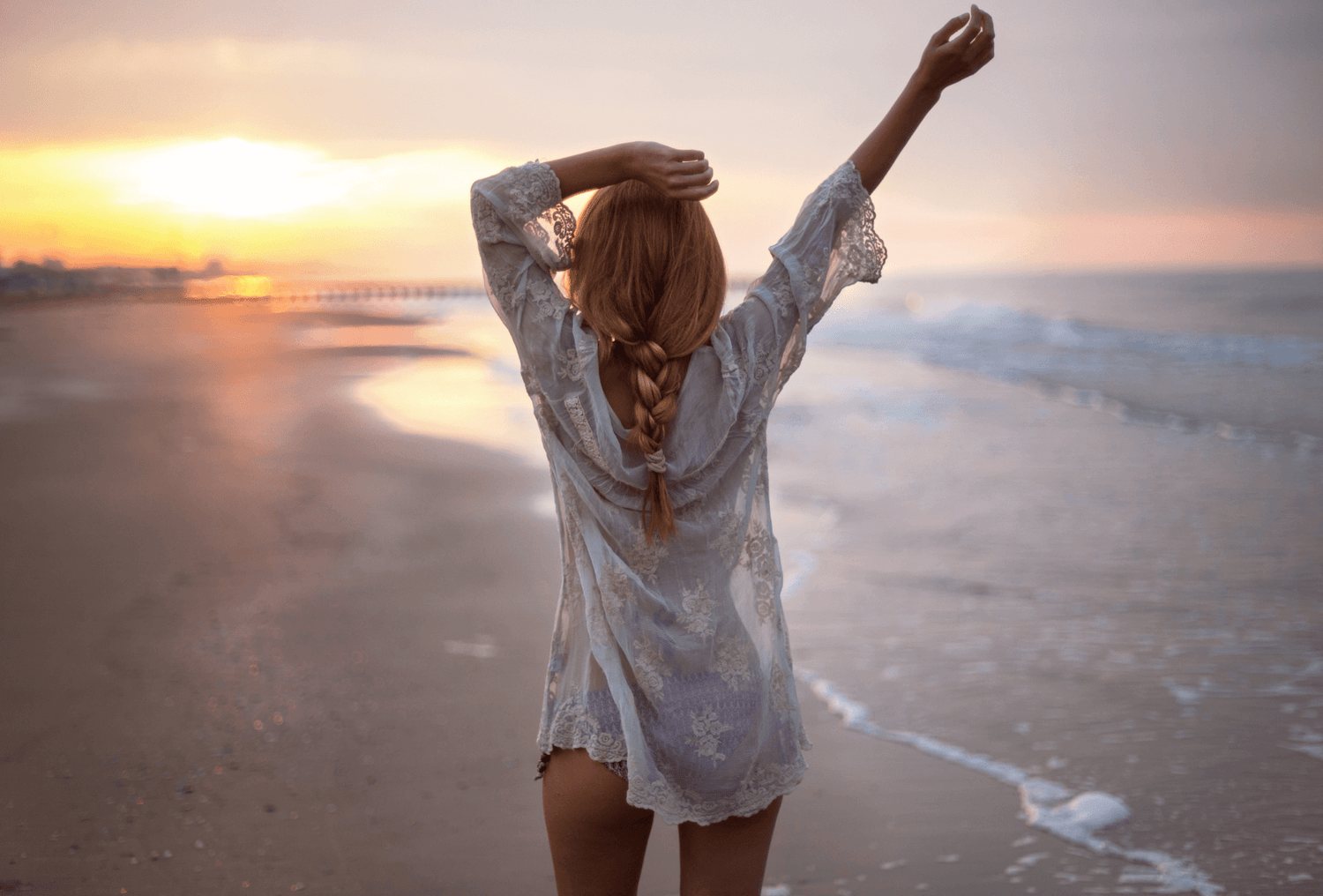 junge frau mit dichtem und langem Haar am Strand