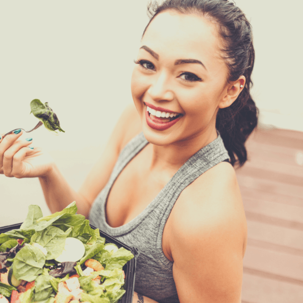 junge Frau mit vollen Haaren isst einen Salat